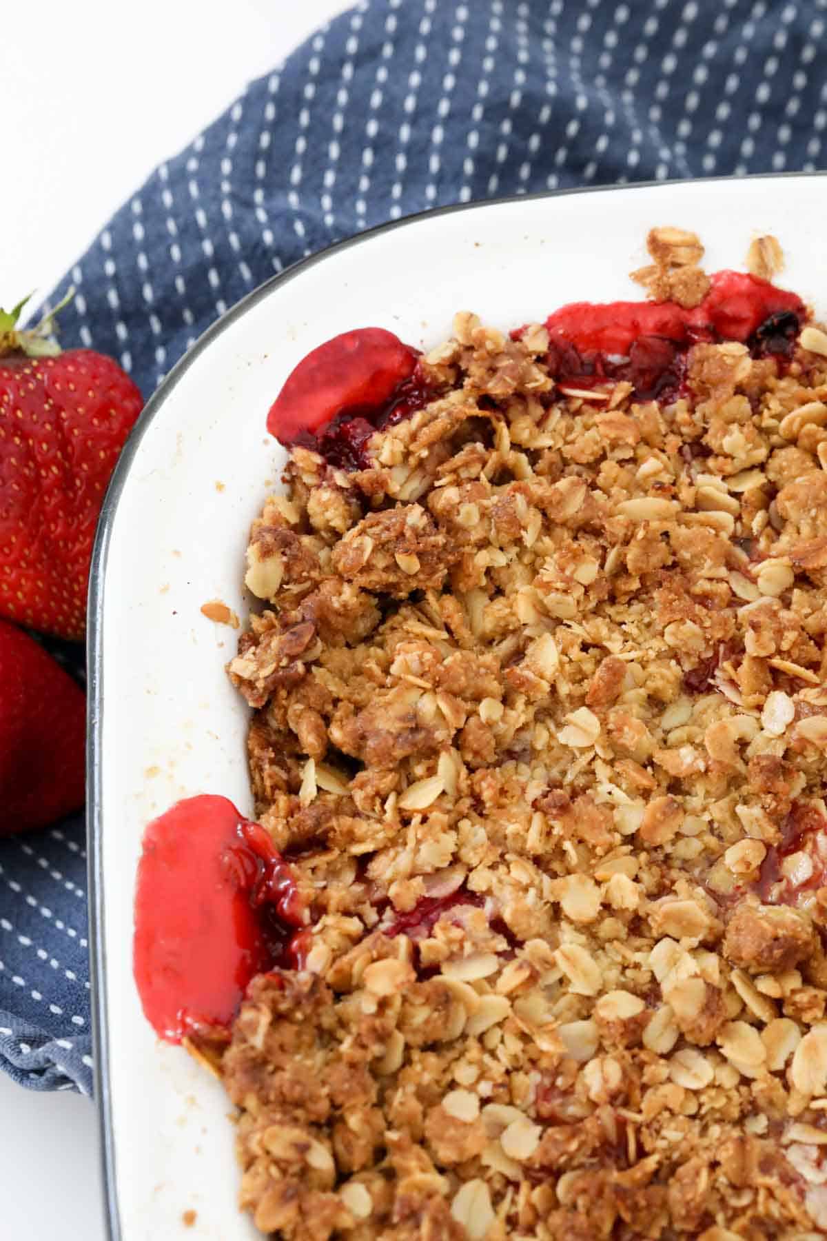 Rolled oat crunchy topping over a dessert in a white baking dish.