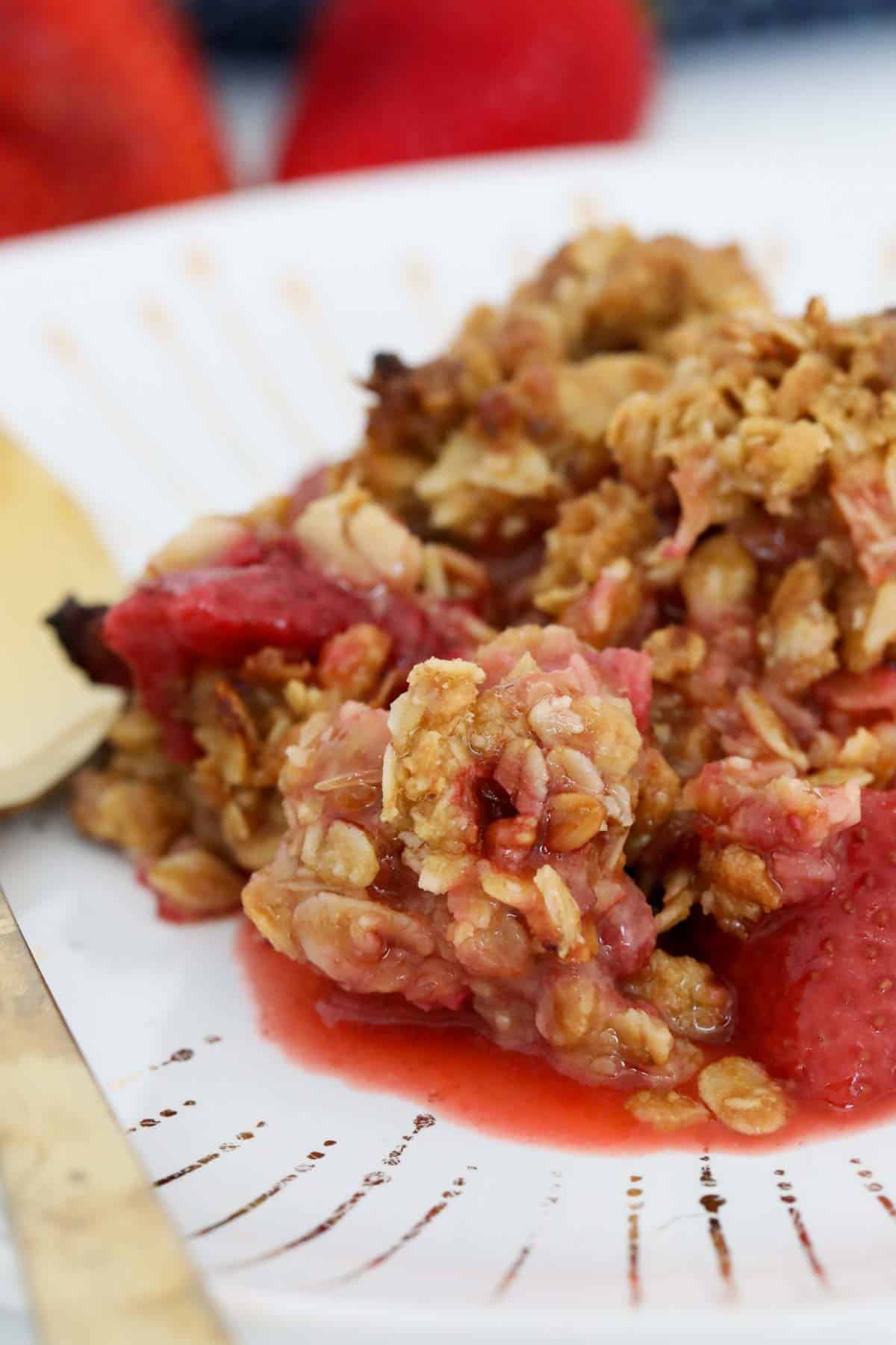 A serve of juicy strawberry dessert with crunchy crumble on top.