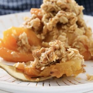 A plate of soft apricots with a crunchy crumble on top.