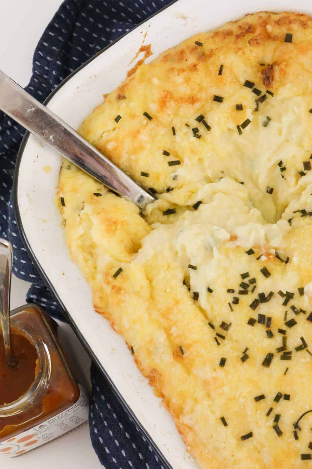 Cheesy mashed potatoes in a serving dish.