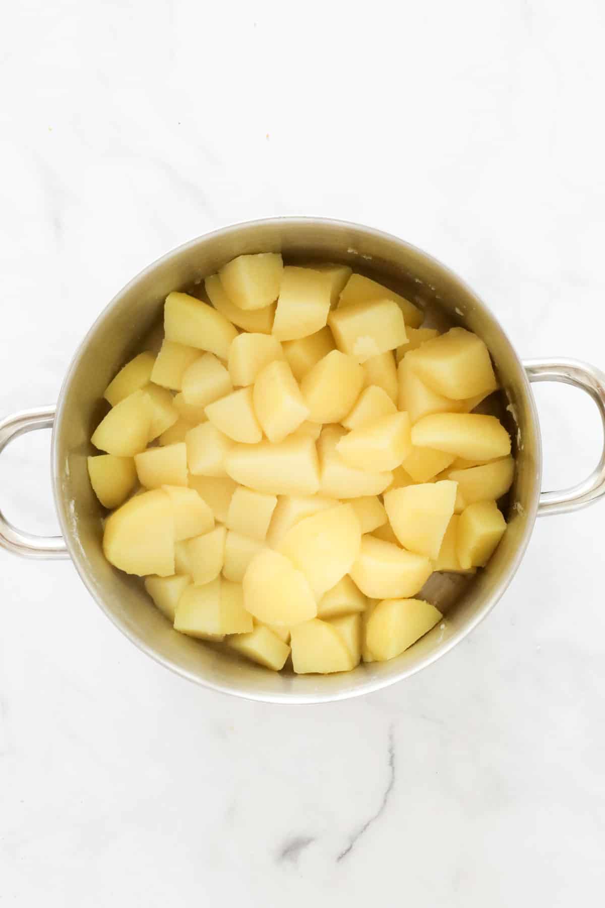 Chopped potatoes in a saucepan.
