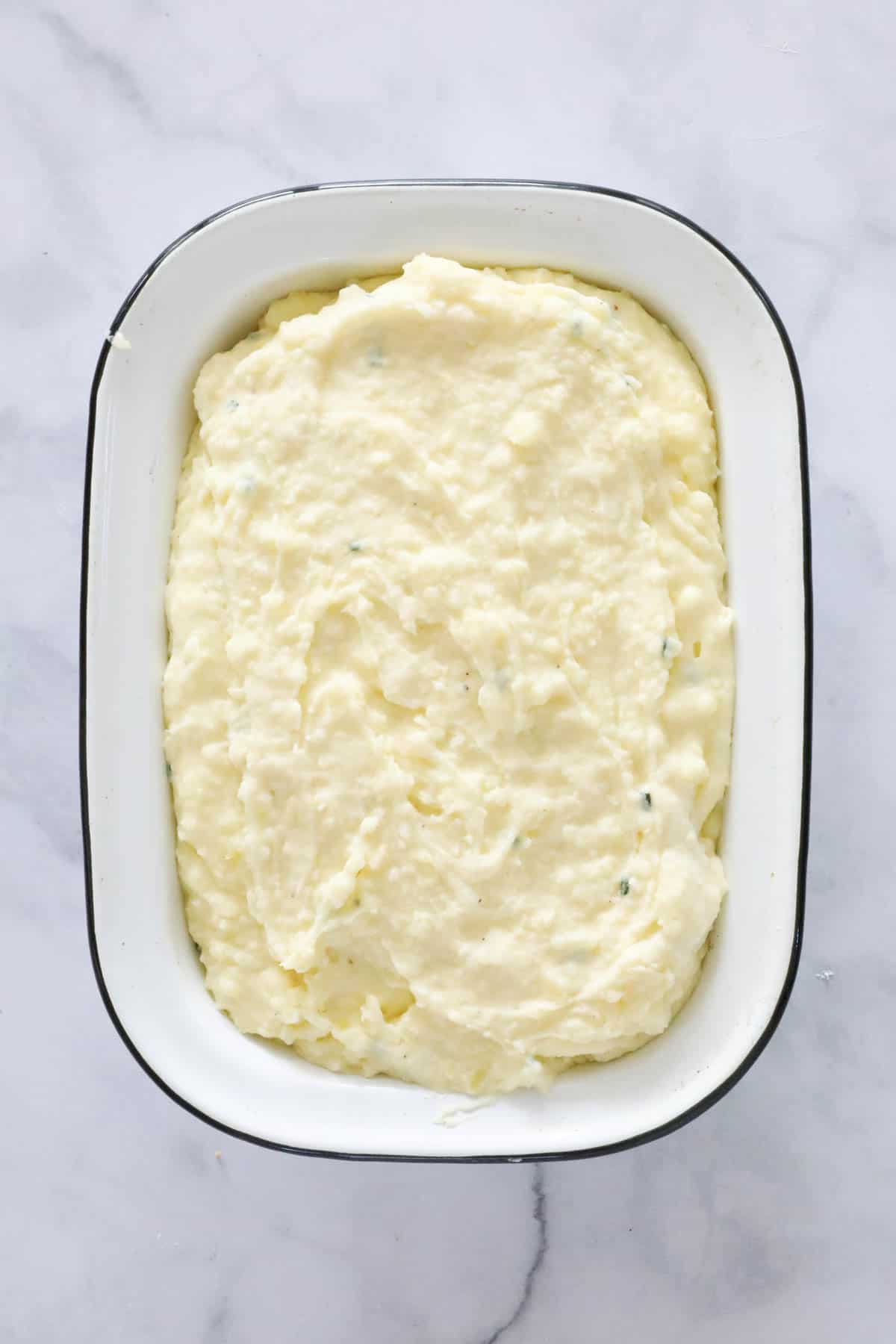 Mashed potatoes spooned into a baking dish.