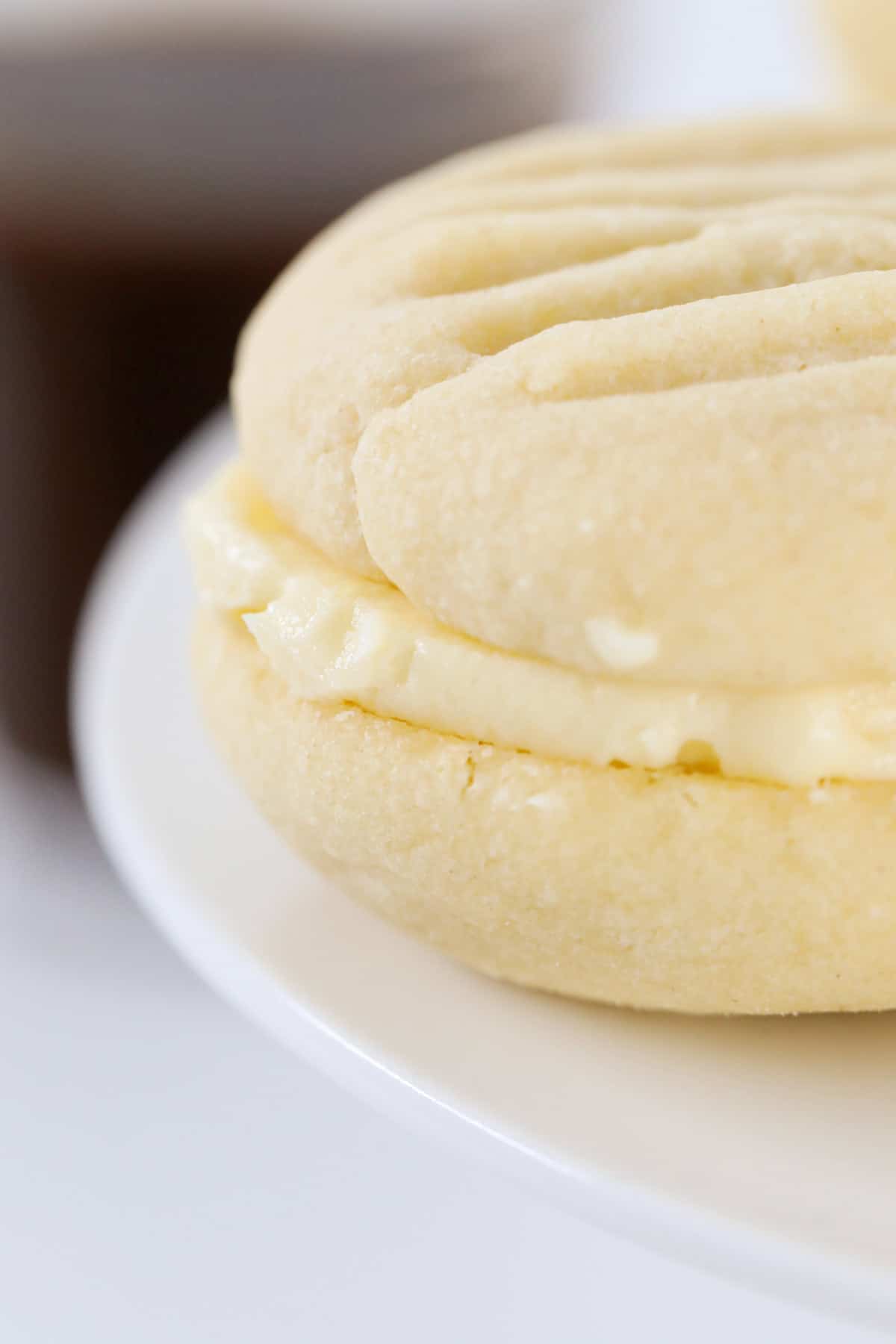 A close up of a sweet Melting Moment filled with lemon icing.