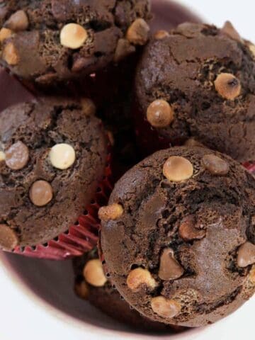 An overhead shot of chocolate muffins with chocolate chips.