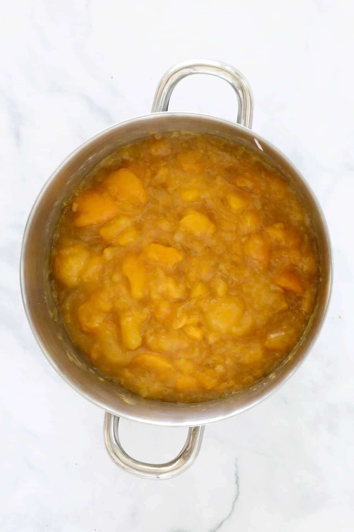 Apricots and thickened syrup in the saucepan.