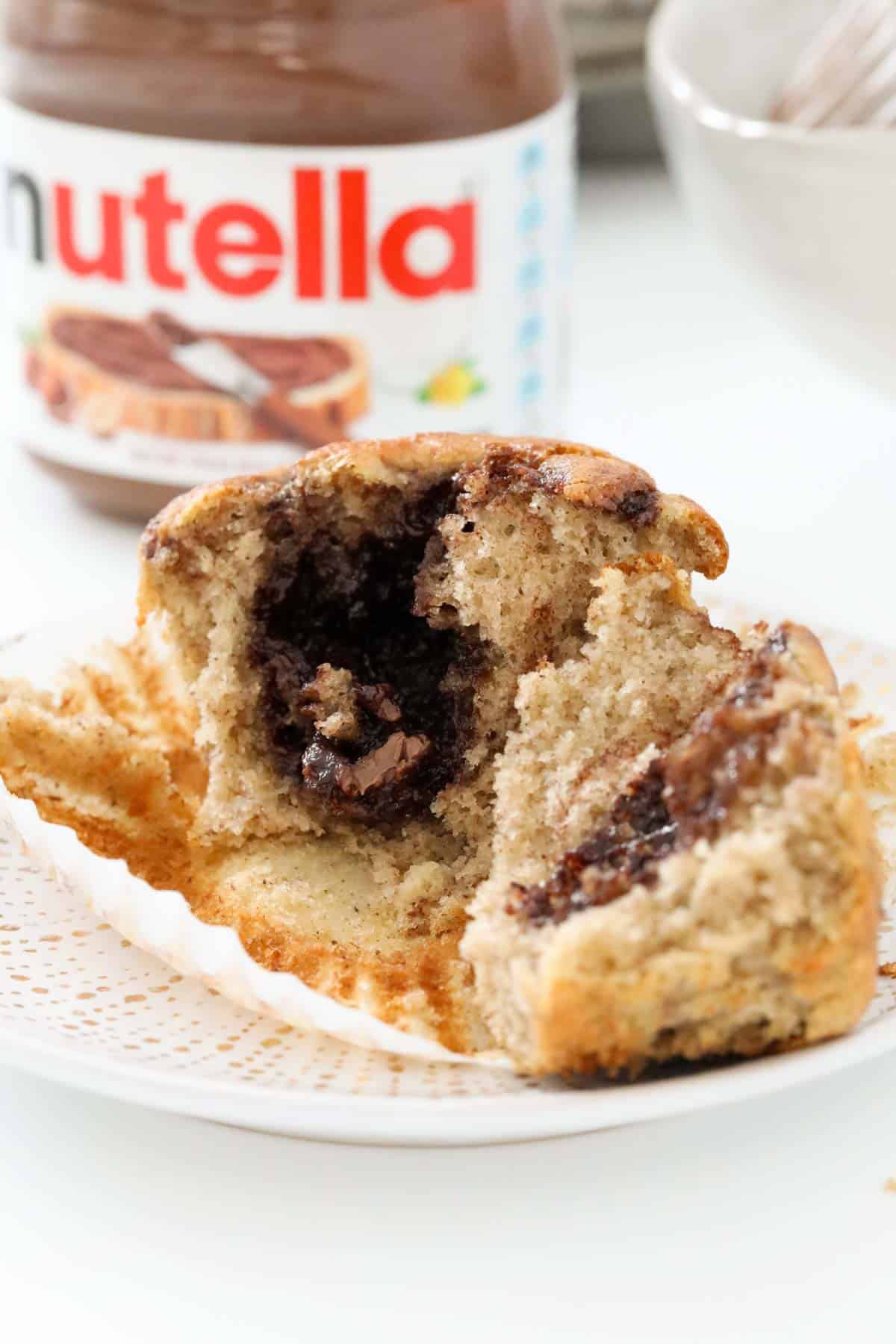 A banana and Nutella muffin split in two to show the swirls of Nutella.