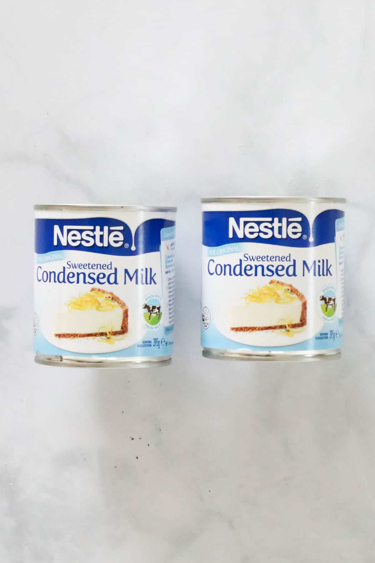 Two tins of Nestle condensed milk.