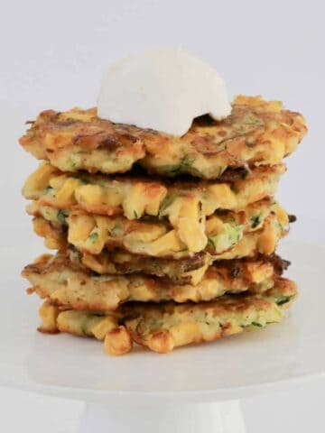 A stack of crispy panfried corn and zucchini fritters.