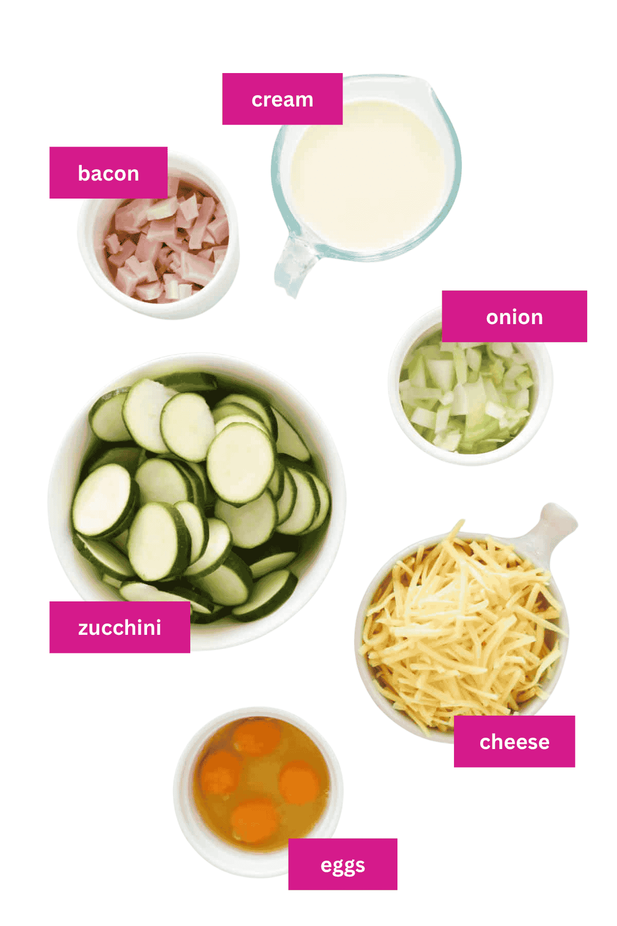 The ingredients for a zucchini quiche laid out in bowls.