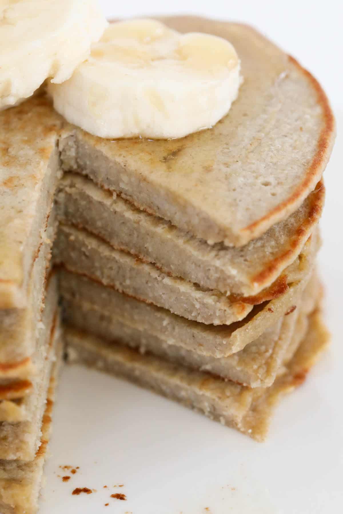 A stack of pancakes with a portion cut out to show the texture.