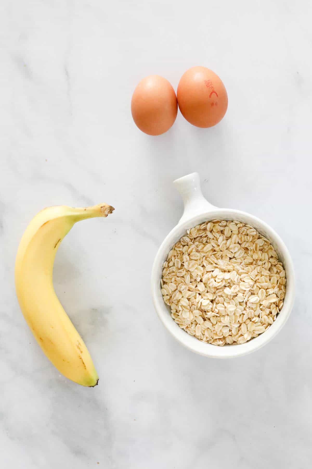 The ingredients needed to make the recipe: 2 eggs, a bowl of oats and a banana.
