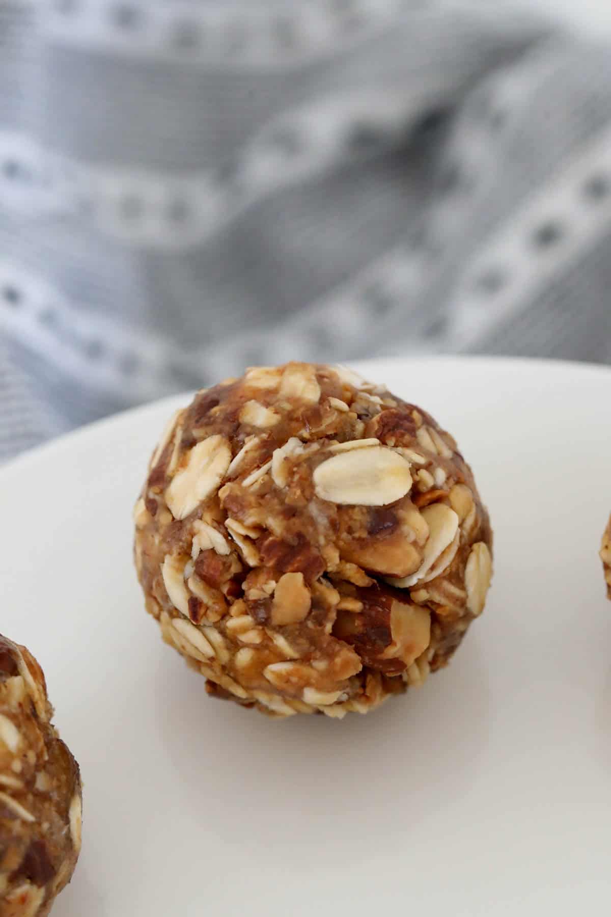 A close up showing oats and chopped almonds rolled into a ball.