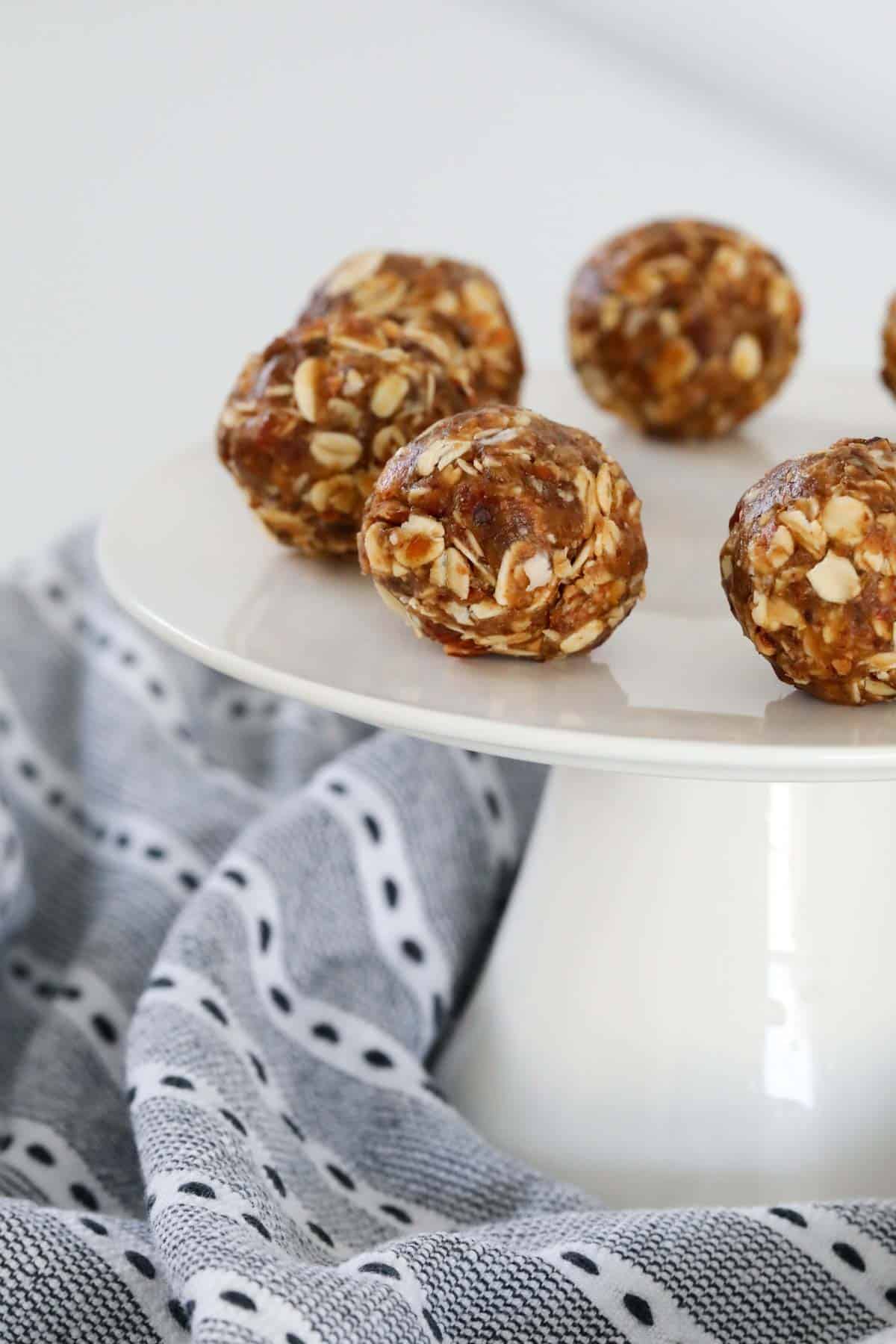Energy balls served on a white cake stand.