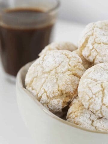 A bowl of almond Italian biscuits coated in sugar.