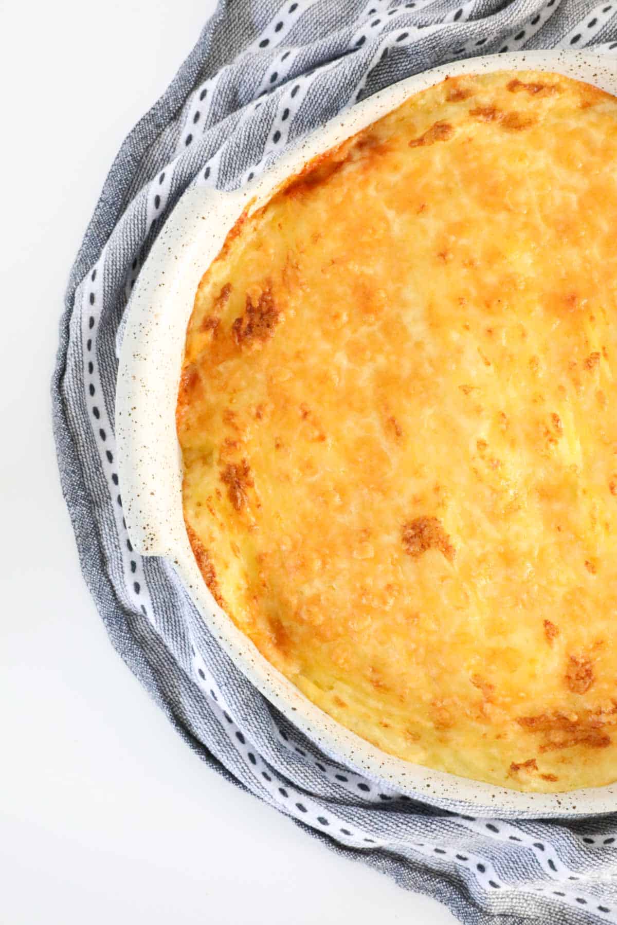 An overhead shot of a cheesy baked cottage beef pie.