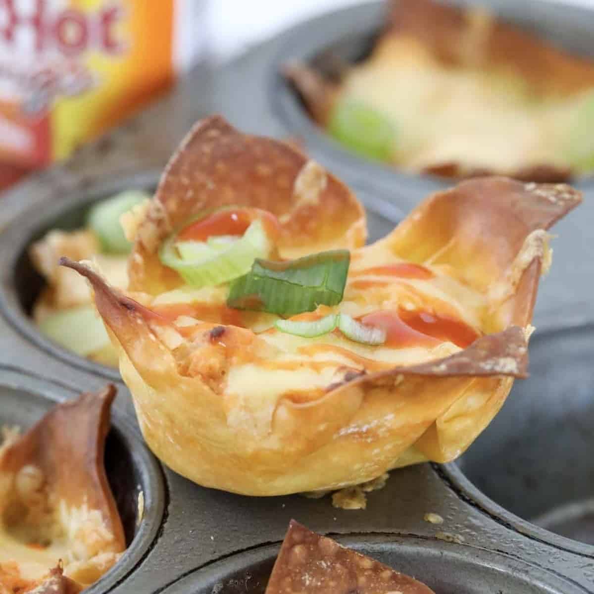 Buffalo chicken wonton wrappers with hot sauce.