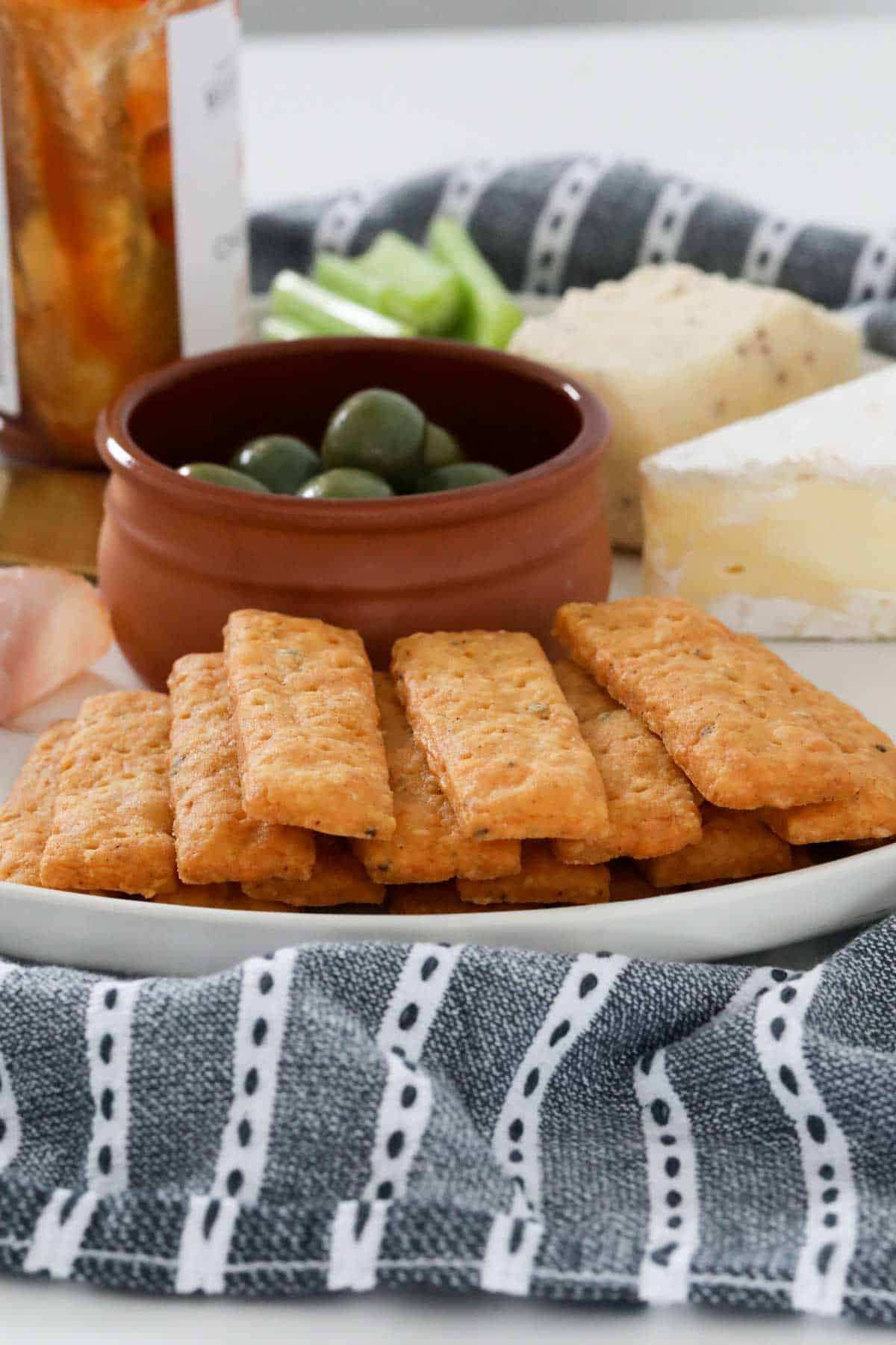 Cheese sticks served with a bowl of green olives.