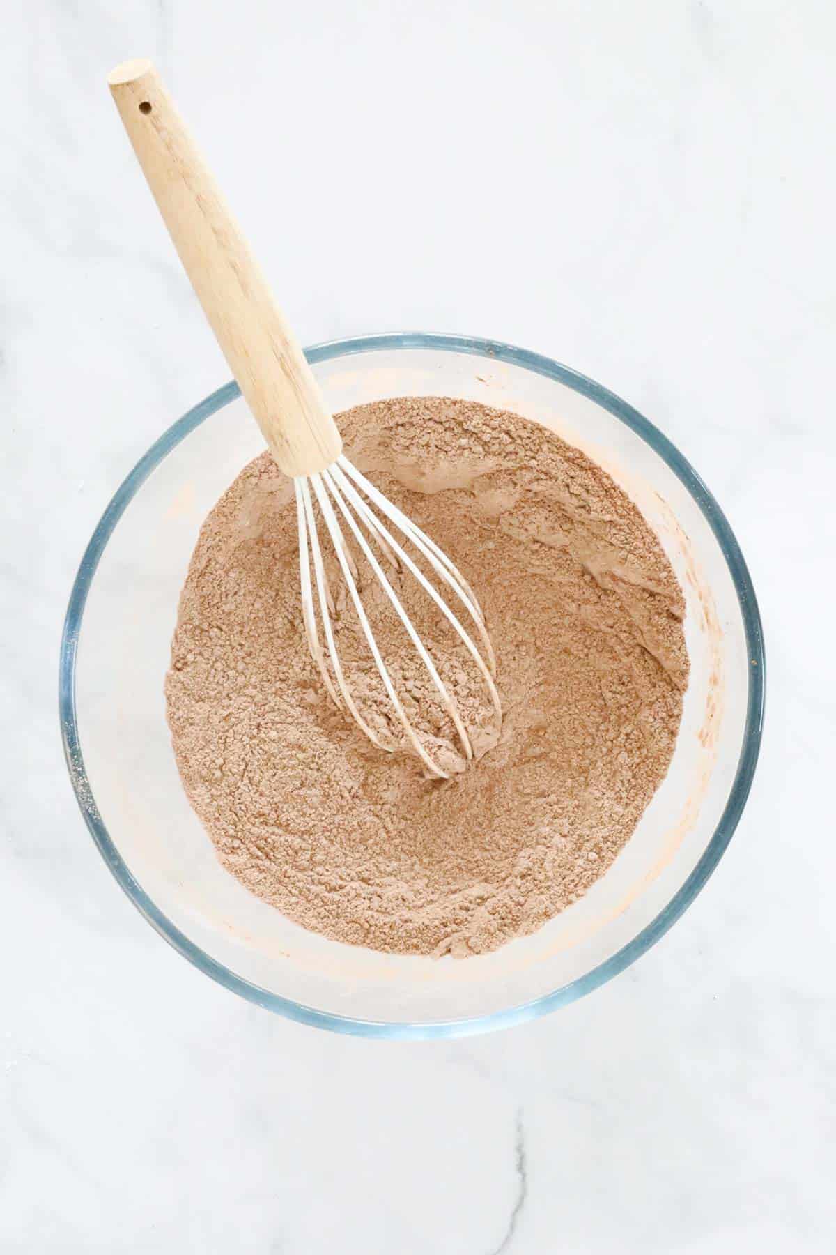 Flour and cocoa powder whisked together in a mixing bowl.