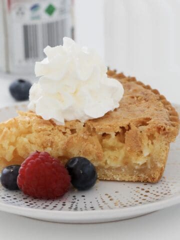 A slice of coconut pie with cream on top.