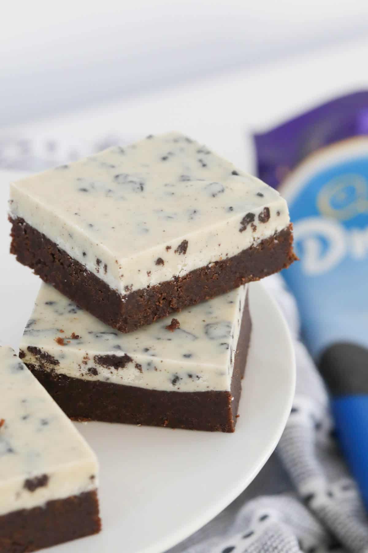 Squares of cookies and cream slice stacked on top of each other.