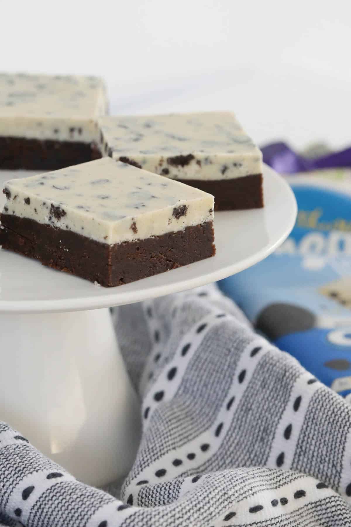 Squares of cookies and cream slice on a cake stand.