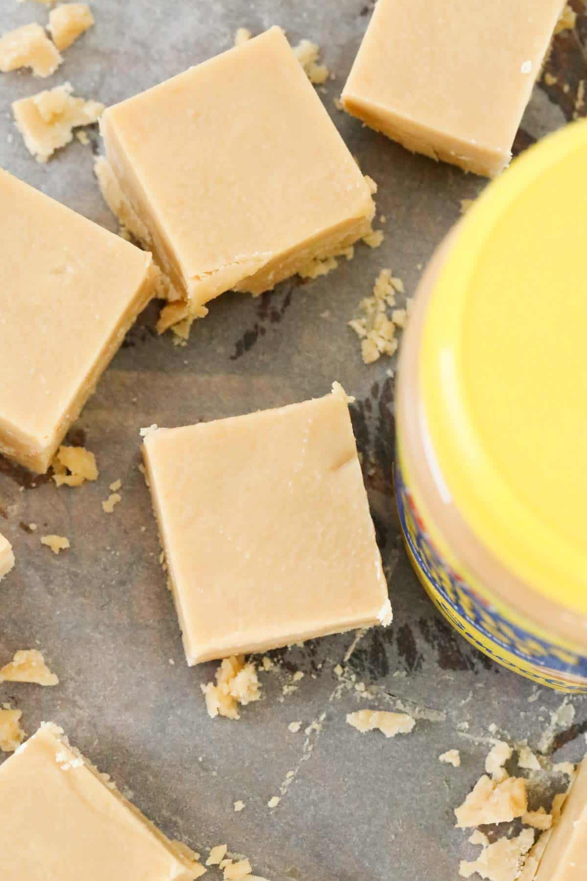 Overhead shot of squares of fudge and the yellow top of a jar.