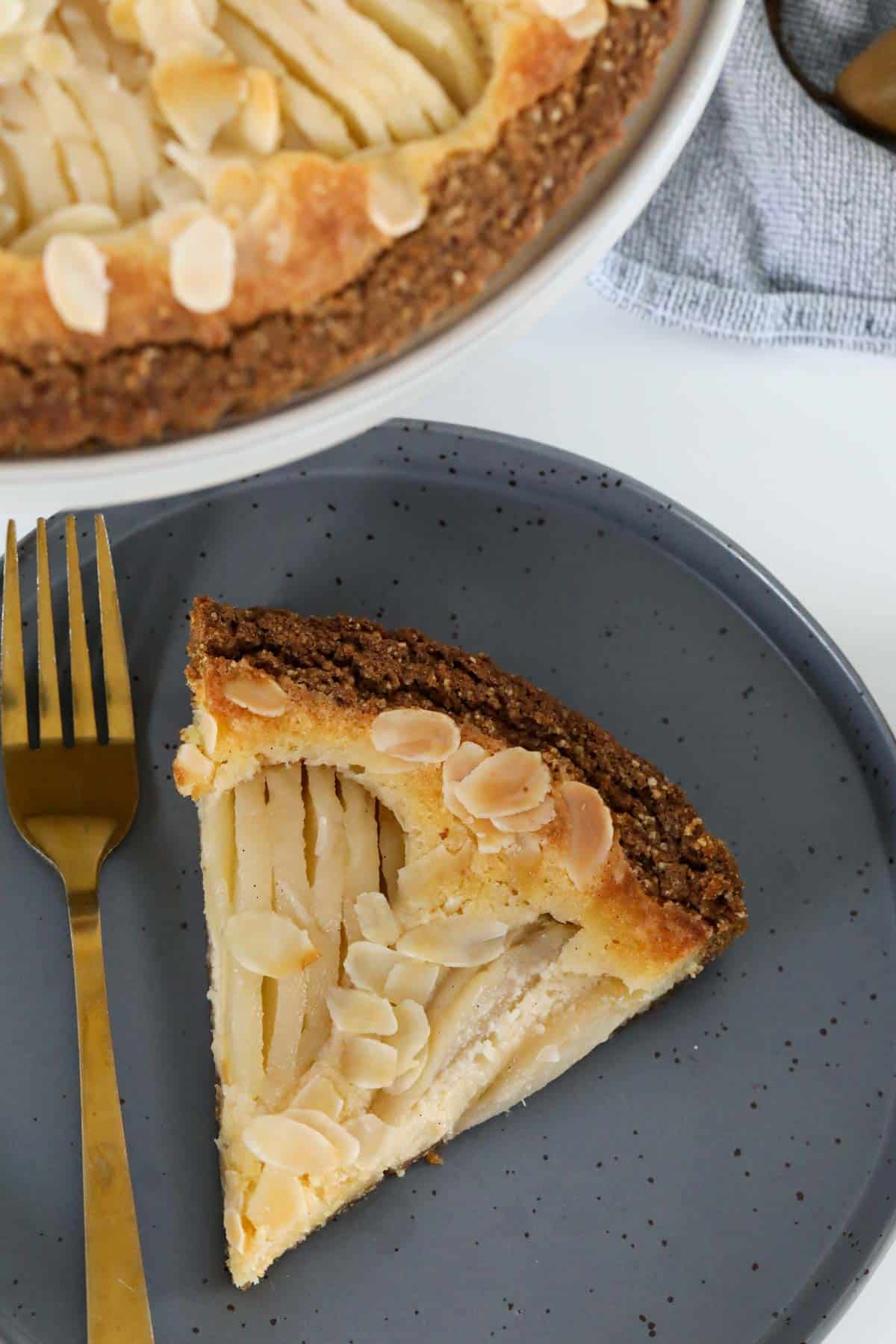 An overhead shot of a slice of almond and pear tart.