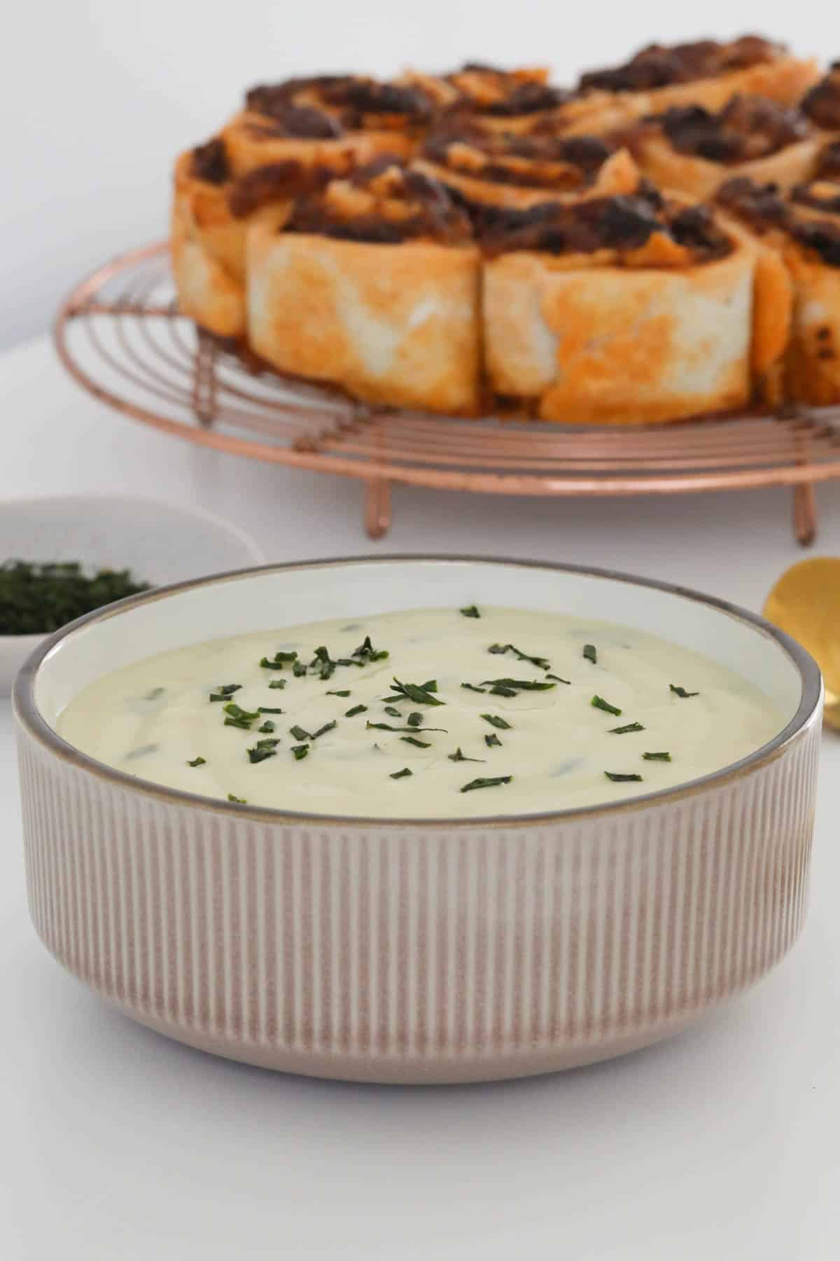A bowl of potato and leek soup with chopped chives sprinkled on top.