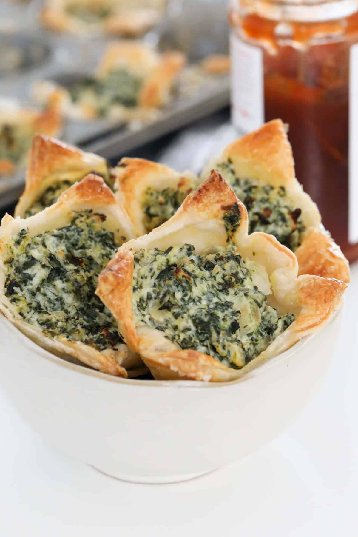 A bowl filled with baked spinach and ricotta tarts.