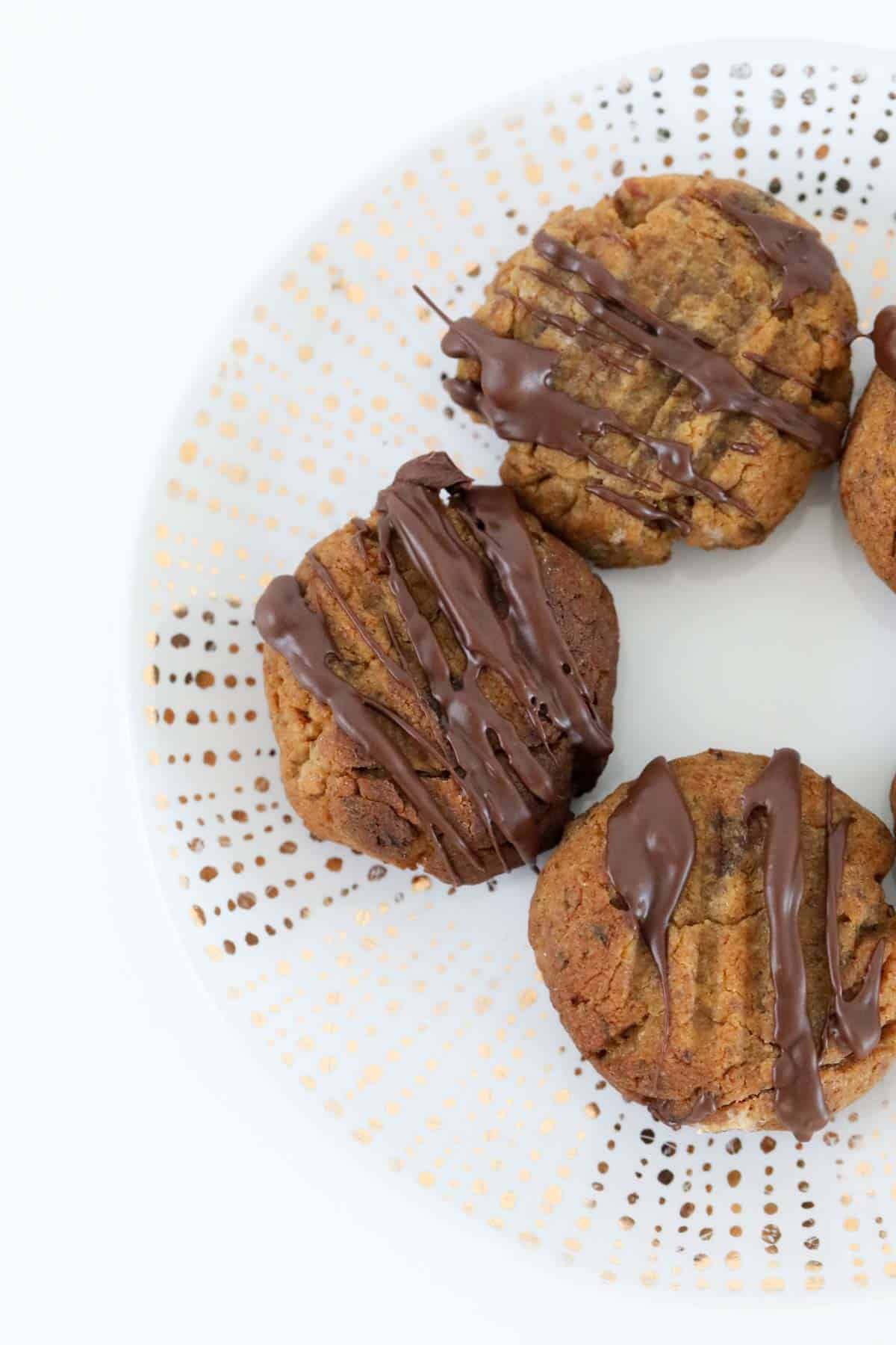 sticky date cookies drizzled with chocolate on a plate.