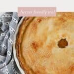 A golden baked apricot pie in a white pie dish, resting on a tea towel.