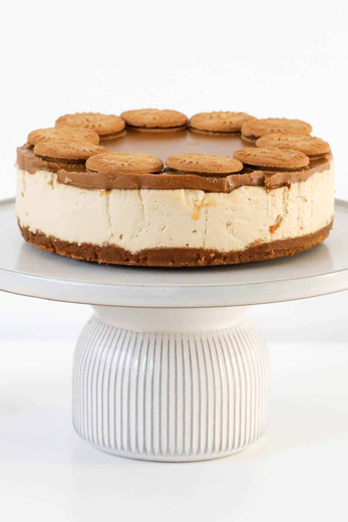 A no-bake Biscoff cheesecake dessert on a cake stand.