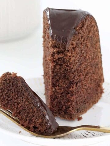 A piece of chocolate cake with half on a fork.