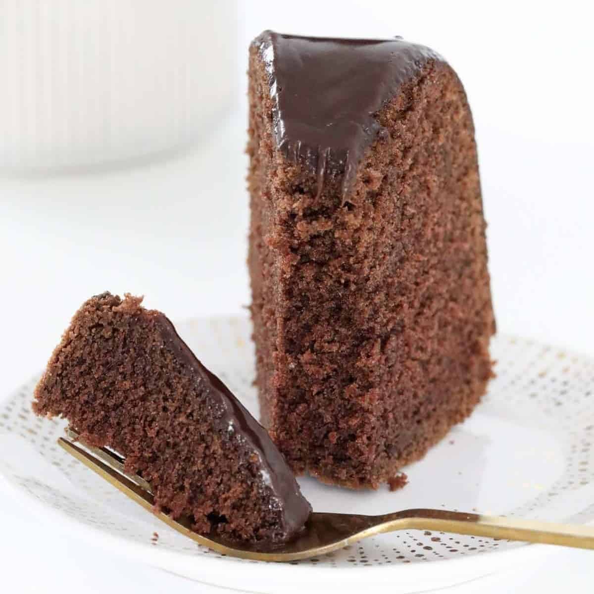 A piece of chocolate cake with half on a fork.