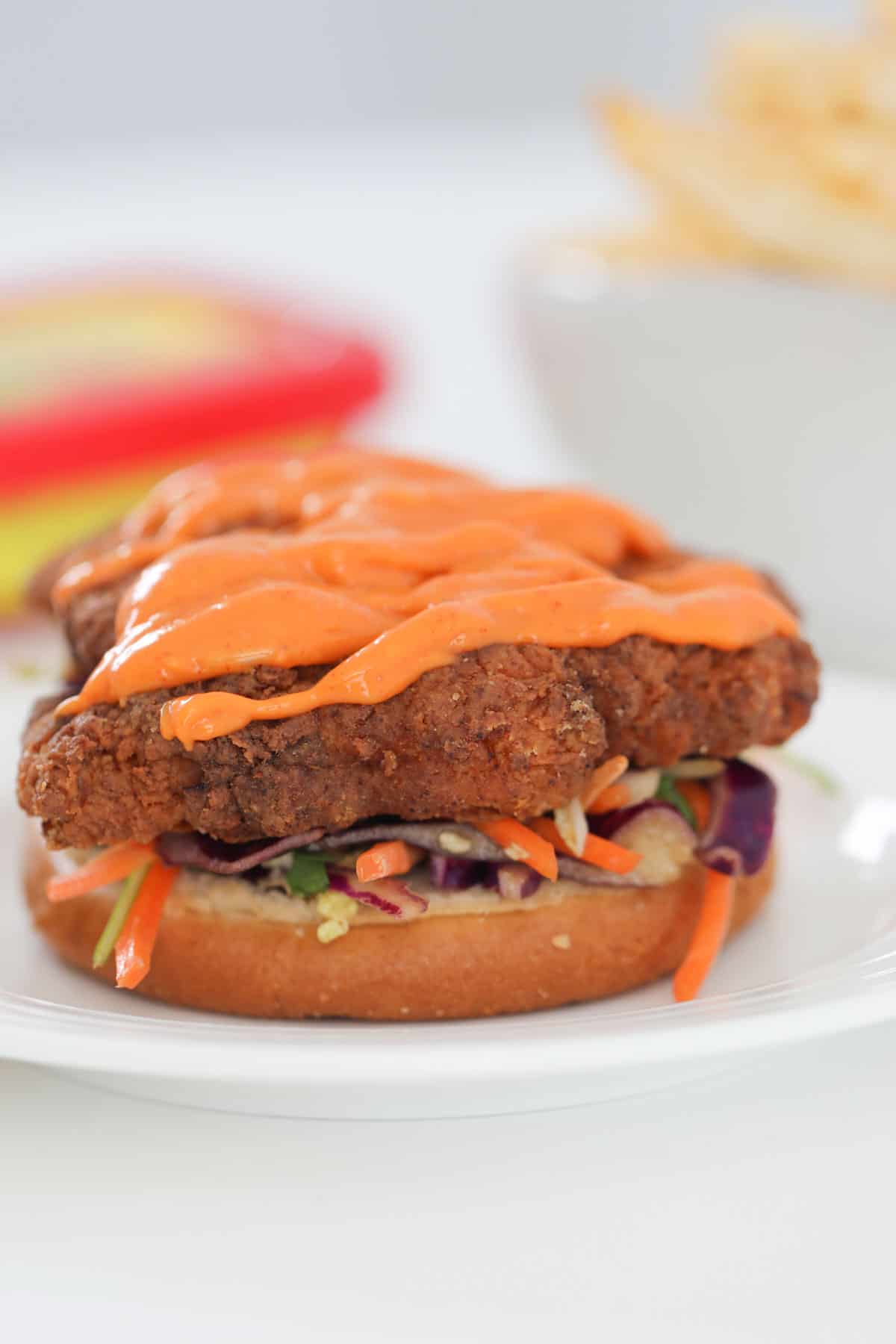 Korean mayo on top of a crunchy fried chicken thigh with slaw.