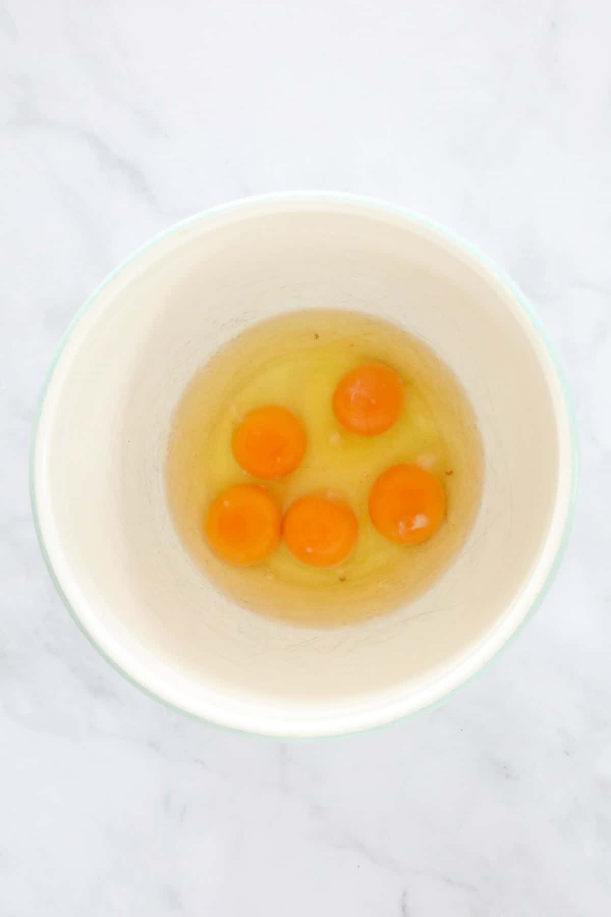 The 5 eggs in a mixing bowl.