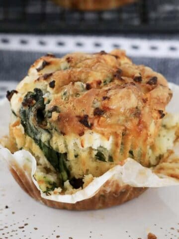 A golden baked muffin with baby spinach and feta.
