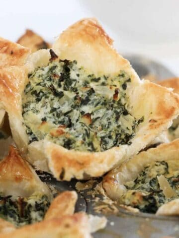 Spinach tarts with ricotta and crispy puffed pastry in a bowl.