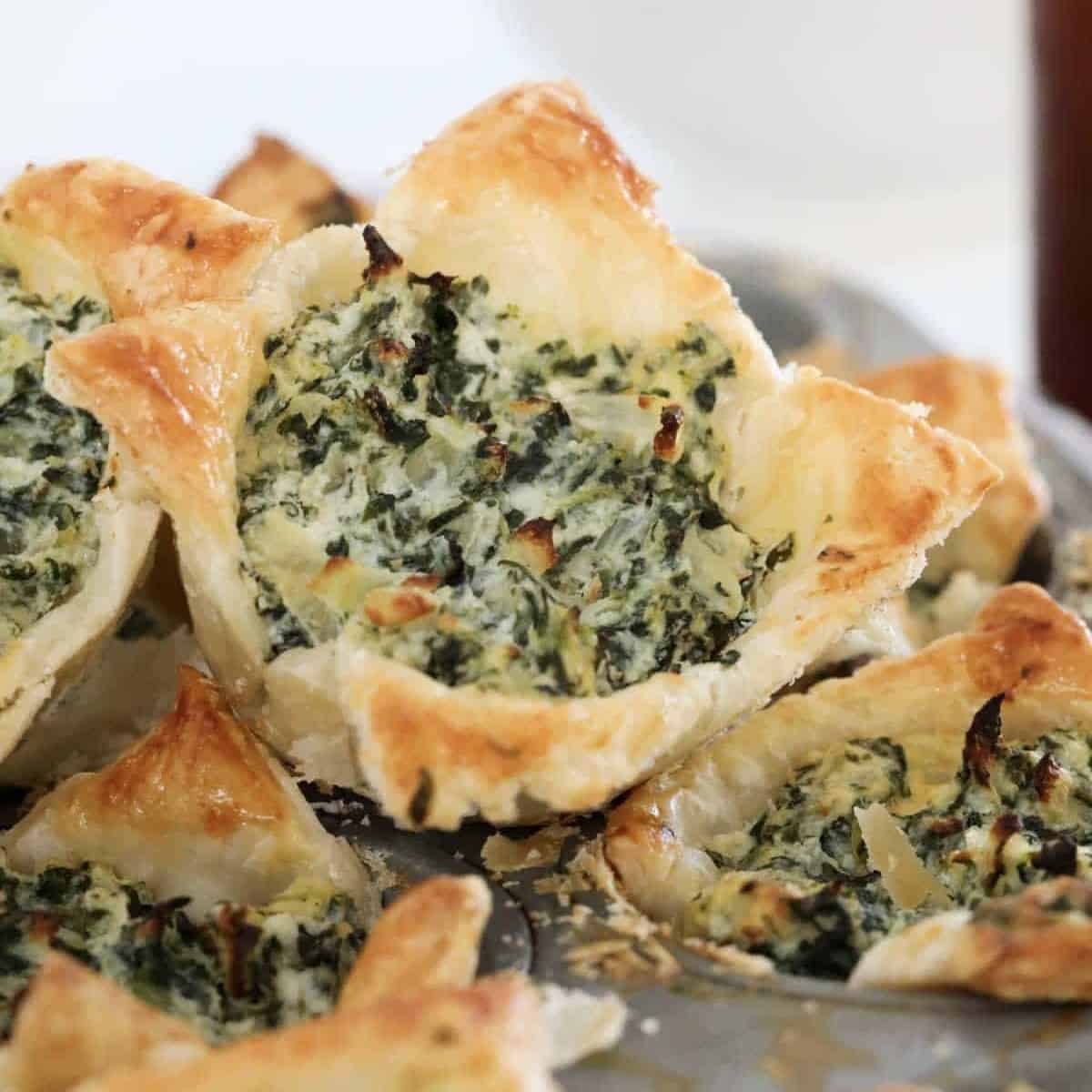 Spinach tarts with ricotta and crispy puffed pastry in a bowl.
