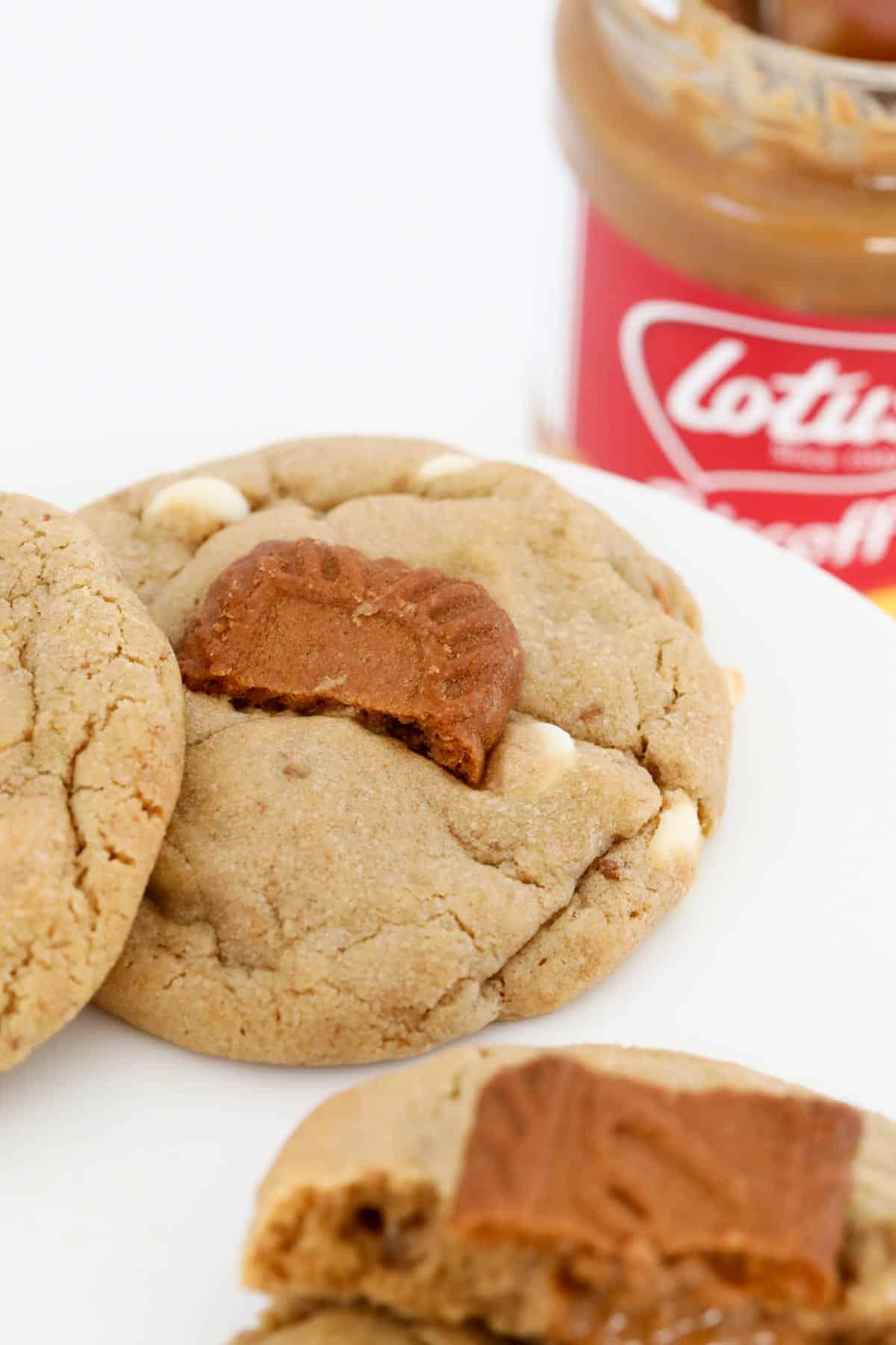 A close up of baked cookies in front of a jar of Biscoff spread.
