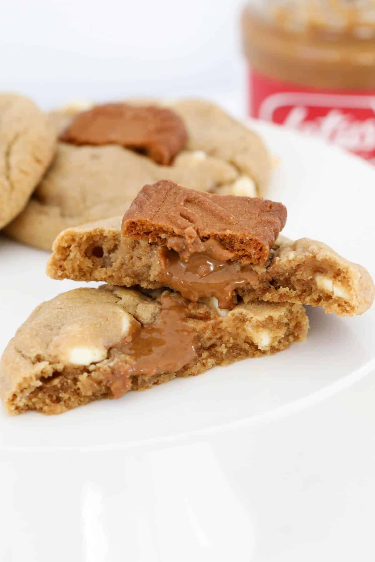 Biscoff cookies on a plate with the front one broken in half to show filling inside.
