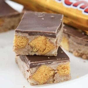 Squares of Crunchie slice with bursts of honeycomb through, and topped with a layer of milk chocolate.