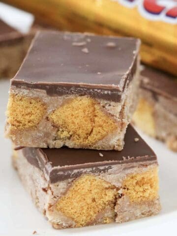 Squares of Crunchie slice with bursts of honeycomb through, and topped with a layer of milk chocolate.