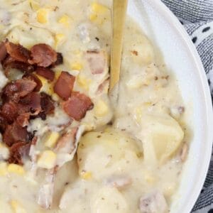 A bowl of Creamy Chicken And Corn Soup with potatoes and bacon.