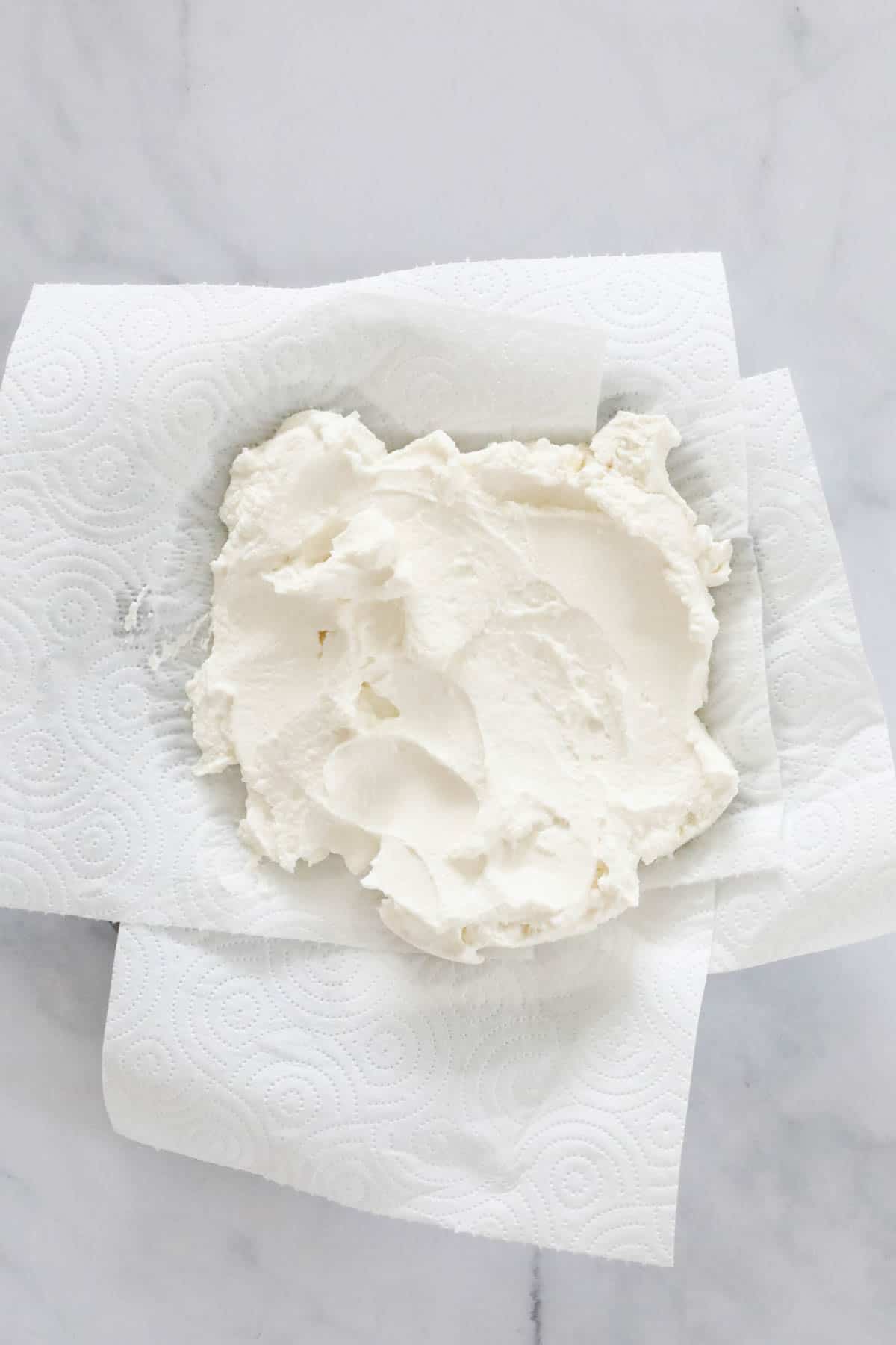 Fresh ricotta placed on paper towels to drain.