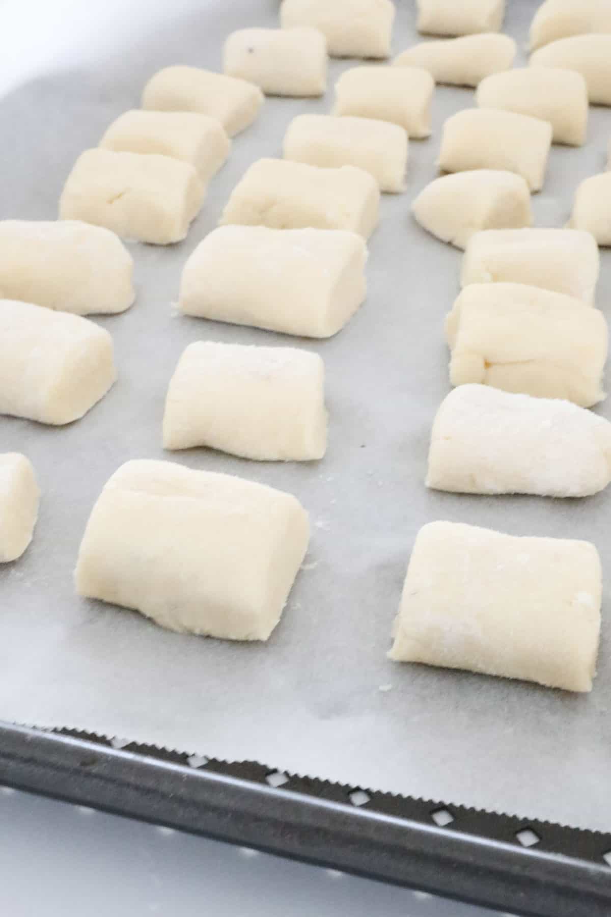 Gnocchi cut and placed on greaseproof paper.