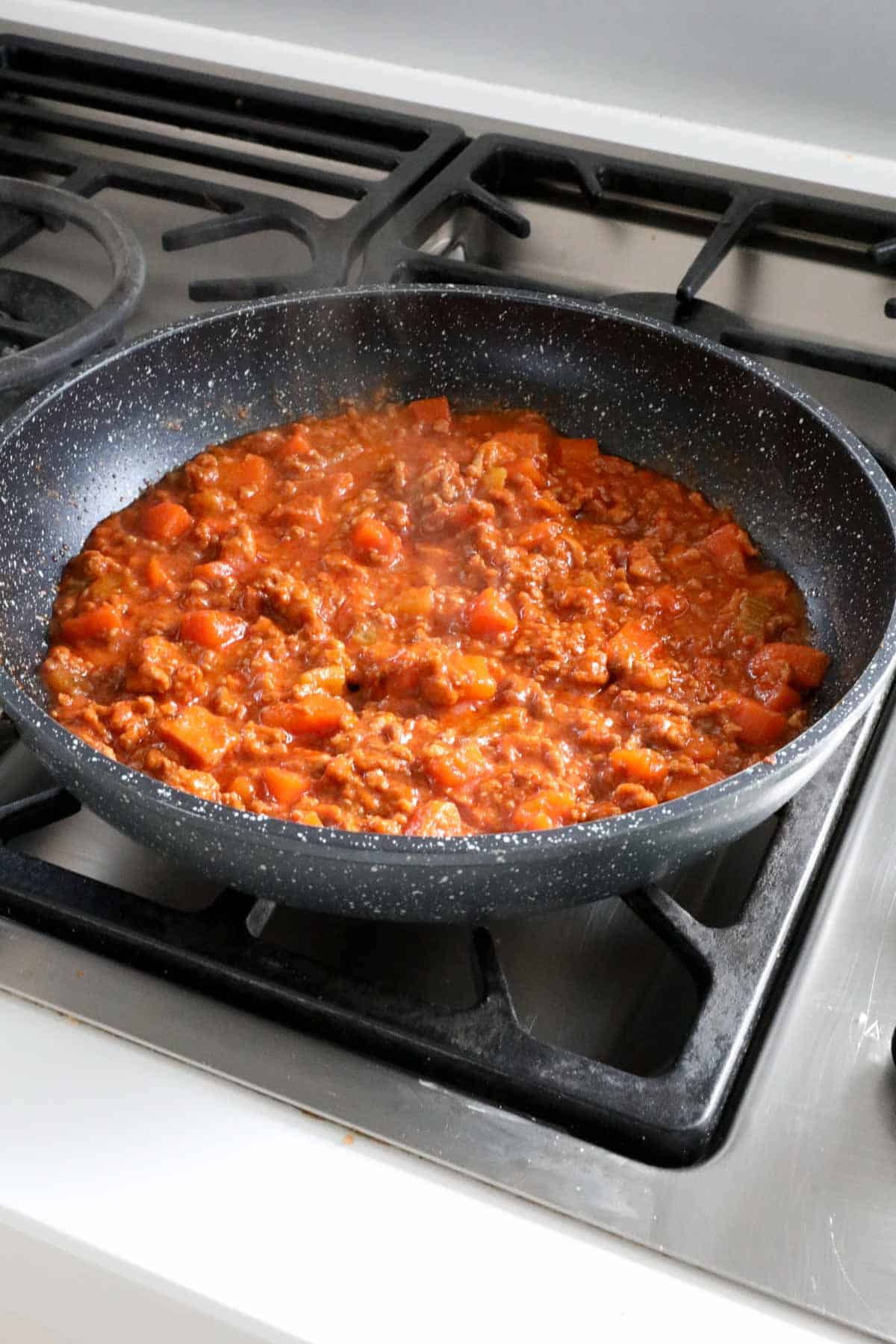 Half the bolognese sauce in a frying pan.