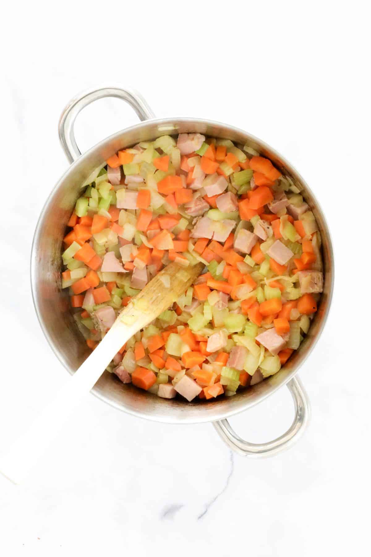 The onion, celery, carrot and pancetta in a saucepan.