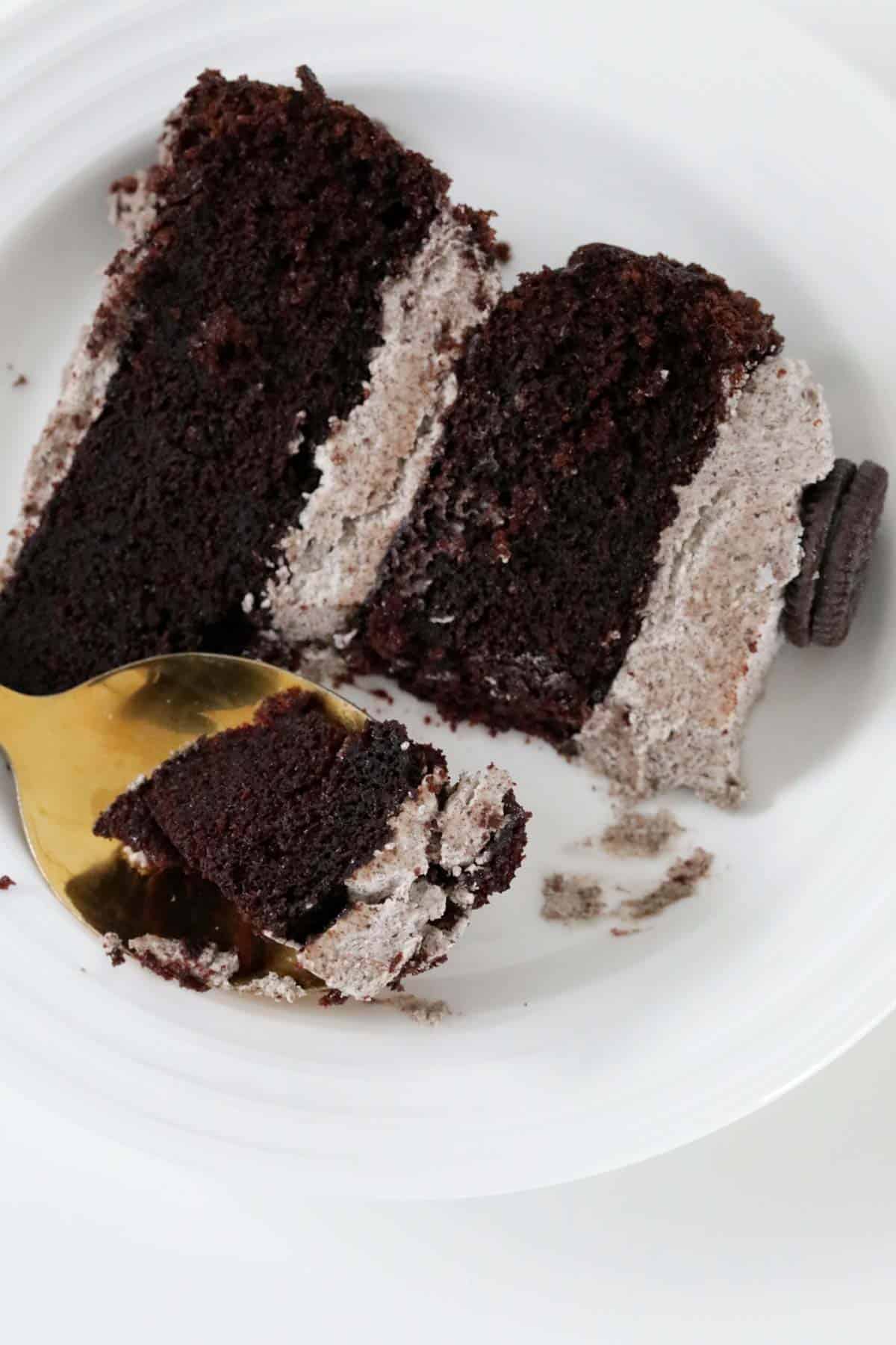 A half eaten piece of fudgy mud cake with Oreo frosting.