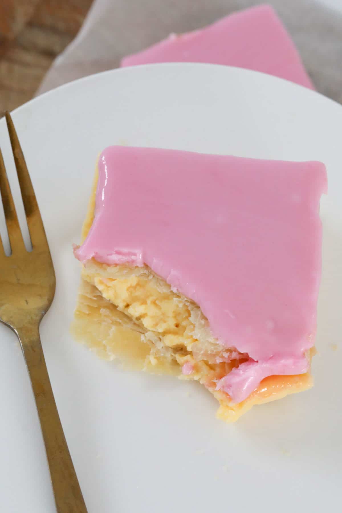 An overhead shot of a vanilla custard slice with a bite taken out.
